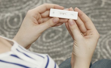 Vrouw kijkt naar zwangerschapstest